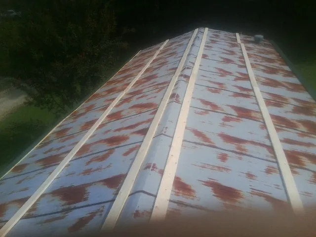 Rusted metal roof panels with new wood purlins before replacement — Storm Damage Roof Repair in Belton by Roofing Brothers