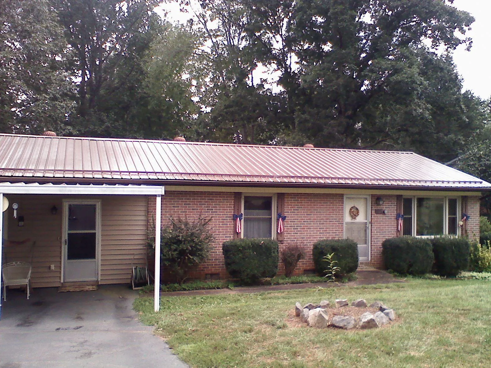 Bronze metal roof and carport on a brick ranch home — Roof Repair work by our crew in Belton